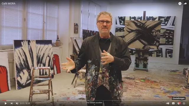 Künstler in farbenverspritzter Kleidung in seinem Atelier